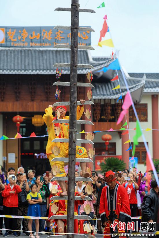 6月3日，非遗传承人在世界自然遗产地梵净山景区表演傩文化上刀山绝技。