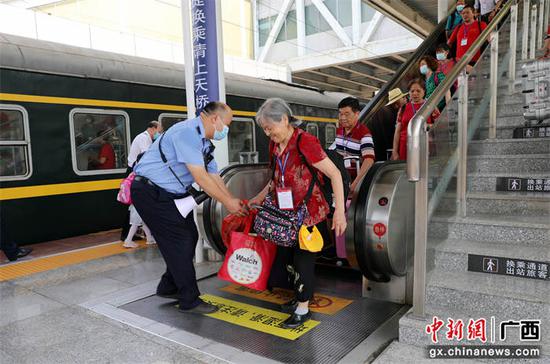 车站工作人员协助游客搬运行李。陈雨雨 摄