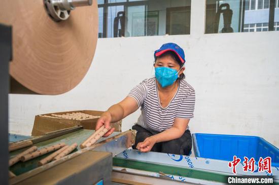 在贵州务川仡佬族苗族自治县一家艾草加工企业，工人在生产车间加工艾条。　唐哲　摄