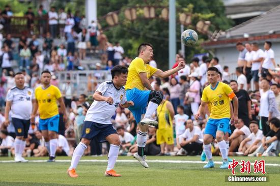 6月10日，忠诚村足球队（白衣）与六佰塘村足球队在比赛中。