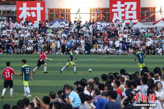 6月10日晚，场坝村足球队（红衣）与丰乐村二队在比赛中。