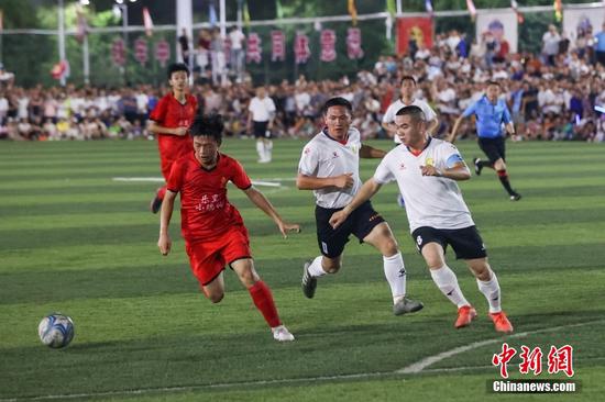 6月10日晚，小瑞村足球队（红衣）与车江三村足球队在比赛中。