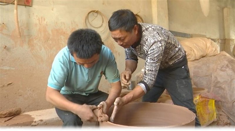 　　6月6日，在牛喜亮的陶瓷廠修坯工坊內(nèi)，牛喜亮（右）正在教牛金鹿修刮陶坯?！　?朱麗君 攝