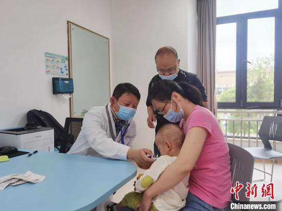 图为上海儿童医学中心贵州医院副院长陈会文为就诊患儿检查身体。　周燕玲　摄