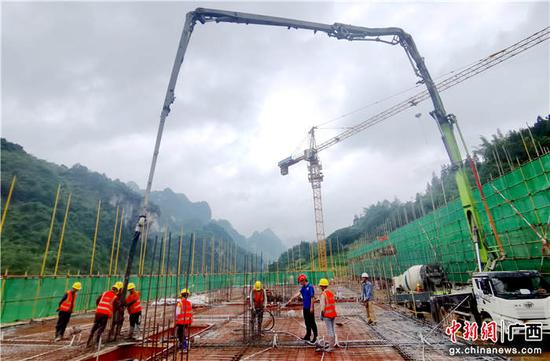 6月16日，工人们在广西凤山县三门海寿源新村进行浇筑作业。高东风  摄