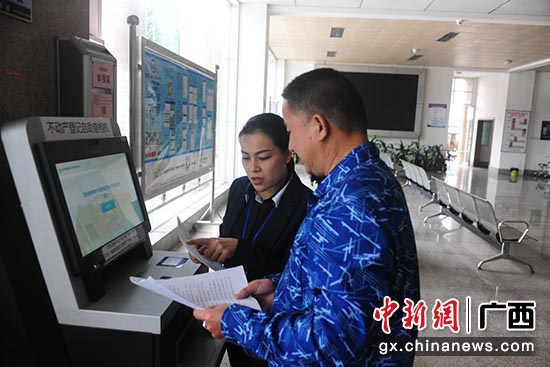 工作人员指导南宁市民进行不动产登记自助查档。