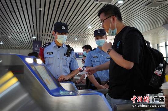 民警正在指导旅客使用实名制验票系统。 陈大鹏  摄