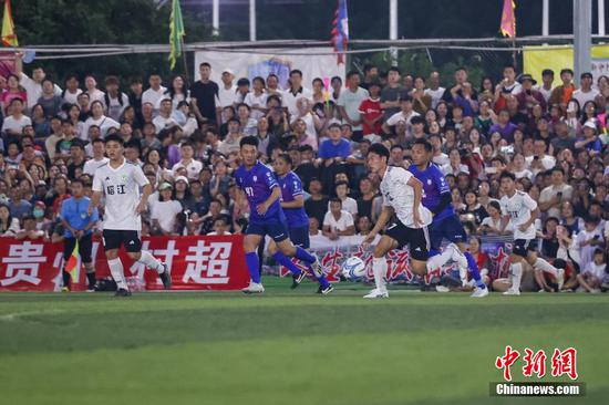 果洛藏族自治州格萨尔王足球队和榕江县村超联队（白衣）在比赛中。