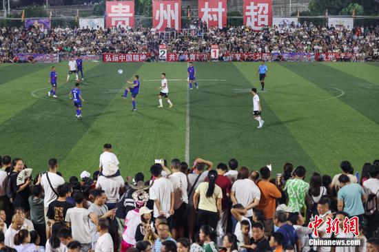 图为果洛藏族自治州格萨尔王足球队（蓝衣）和榕江县村超联队在比赛中。