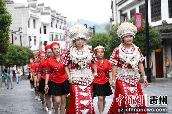 6月22日，人们在贵州黄平县旧州古镇着盛装参加“翱翔旧州·龙腾端午”巡游活动。　陈孝新　摄