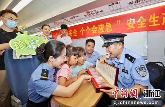 杭州铁路民警在列车车厢内教旅客辨认毒品样品。周围（通讯员）摄