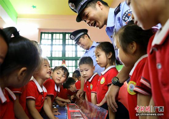 图为民辅警在和小朋友进行禁毒知识互动。甘勇 摄