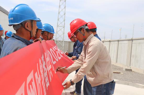 吐鲁番鄯铁110千伏输变电工程项目管理、施工人员进行集体安全承诺签字。刘栋 摄