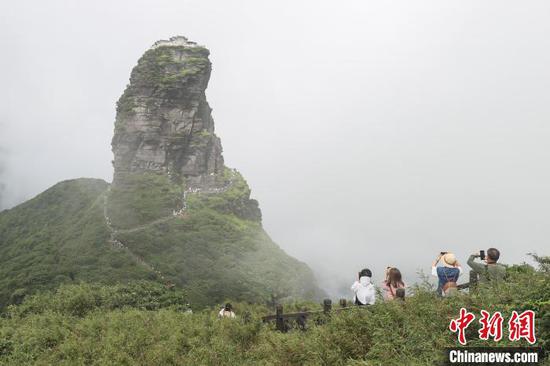 图为游客在拍摄世界自然遗产地梵净山红云金顶云雾景观。　瞿宏伦 摄