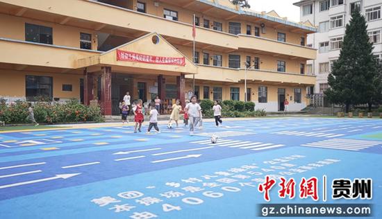 榕江县两汪乡中心幼儿园的孩子们在崭新的操场上踢球。李熠晨 摄
