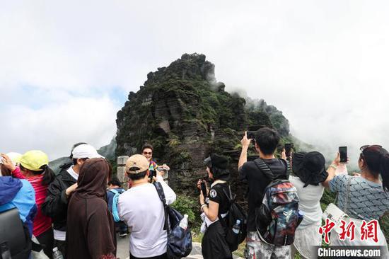 图为游客在拍摄世界自然遗产地梵净山老金顶云雾景观。　瞿宏伦 摄