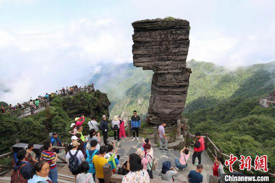 图为游客在世界自然遗产地梵净山蘑菇石下游览。　瞿宏伦 摄