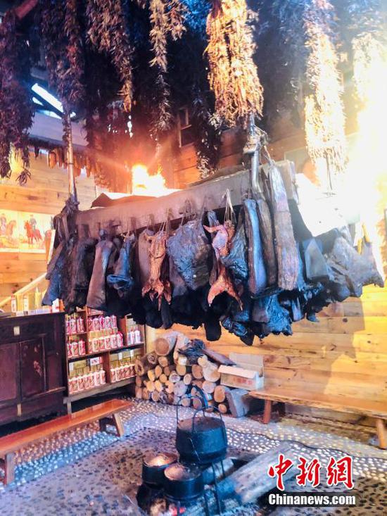 图为云舍村农家乐中悬梁而挂的腊肉等特色美食。