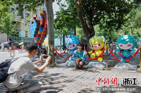 游客在西湖边的杭州亚运会吉祥物前合影。  徐梓齐（实习生） 摄