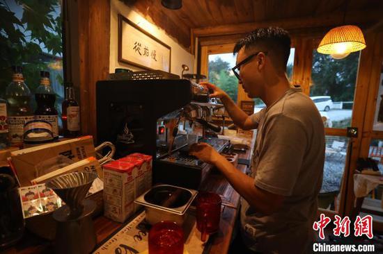 位于贵州省江口县梵净山村的咖啡馆内，张紫电为顾客制作咖啡。　瞿宏伦 摄