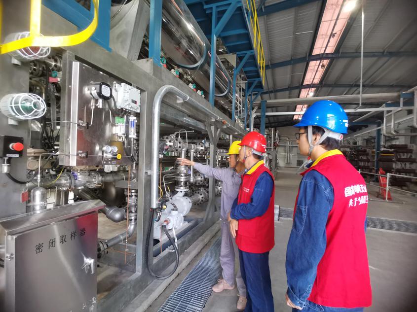 6月30日，国网阿克苏供电公司工作人员努尔 艾合买提和牛宏伟在新疆华电库车（牙哈）550兆瓦光伏发电项目光伏基地了解逆变器工作情况。常帅 摄
