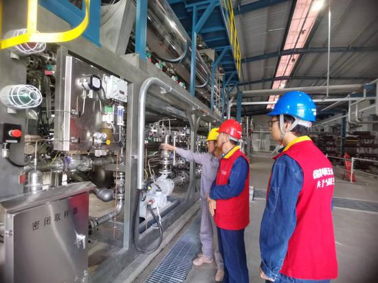 6月30日，国网阿克苏供电公司工作人员赵勇刚和卢可在新疆库车绿氢示范项目电解槽车间了解企业生产用电情况。莫正军 摄
