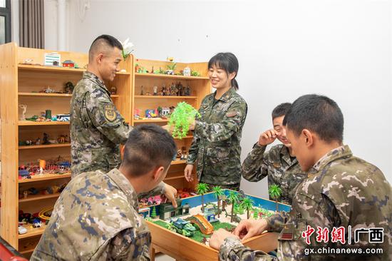 7月3日，武警官兵们与心理医师分享自己挑选的沙盘物件。