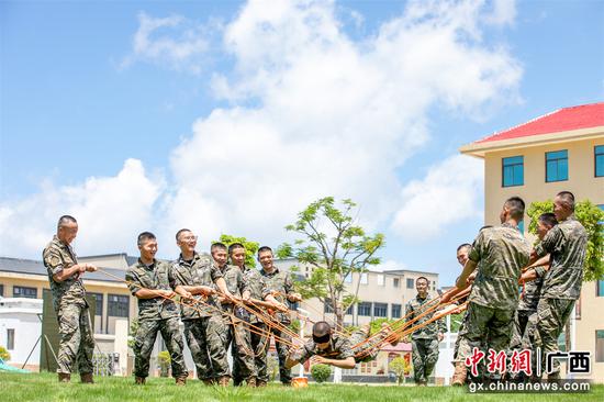 武警官兵们齐心协力进行“雷区取水”游戏。