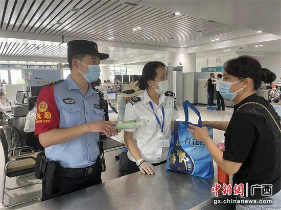 在安检口，民警耐心向旅客解释违禁品携带的原因。陈大鹏  摄