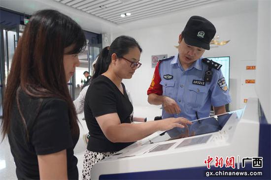 民警正在指导旅客使用“警E邮”自助办理临时身份证明。陈大鹏  摄