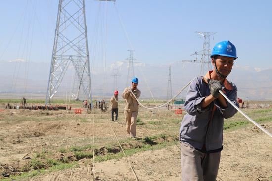 6月11，国网新疆电力施工人员开展阜康抽水蓄能电站—五家渠变电站220千伏线路工程放线施工作业。