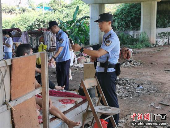 图为民警联合相关部门对铁路桥下闲杂人员进行劝返、清理。刘池玮  摄