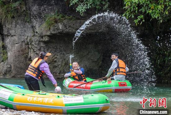 图为游客在施秉县杉木河景区漂流、戏水。
