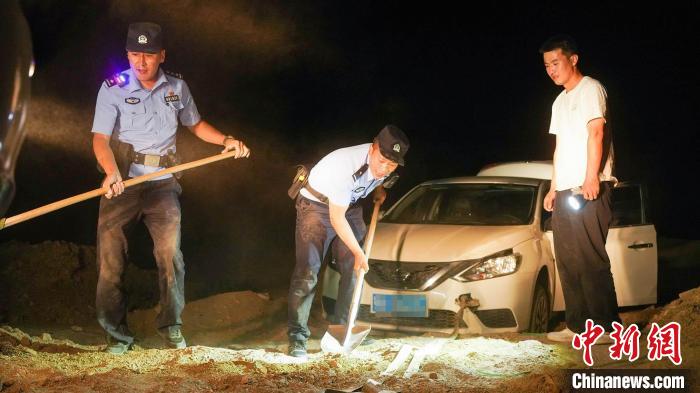 民警穆萨·阿西木（左一）、张昌宁（中）找到被困司机齐某及其助深陷土坑的被困车辆。　靳汉林 摄