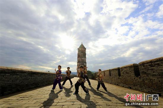 图为孩子们在位于贺州市贺街古镇的文笔塔练习咏春武术套路。甘勇 摄