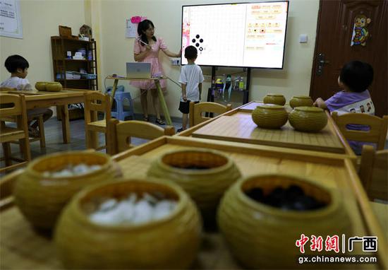 图为孩子们在学习中国传统棋种围棋。甘勇 摄