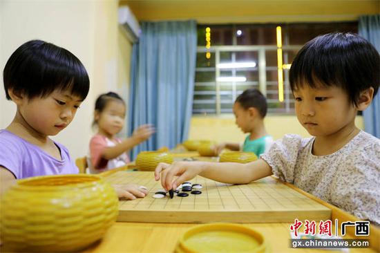 图为孩子们在学习中国传统棋种围棋。甘勇 摄