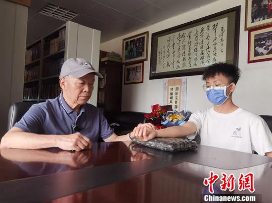 黄汉儒(左)为患者把脉。杨陈 摄