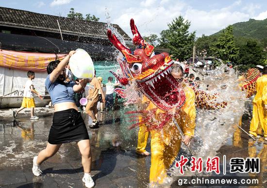 图为游客在贵州省务川县龙潭村水龙节现场玩水狂欢。
