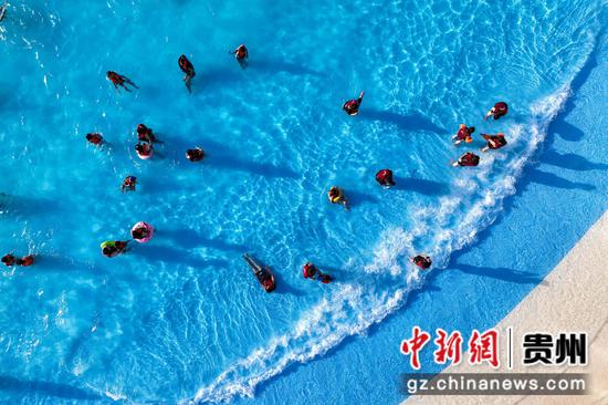 7月16日，民众在水上乐园环形造浪池戏水。 瞿宏伦 摄
