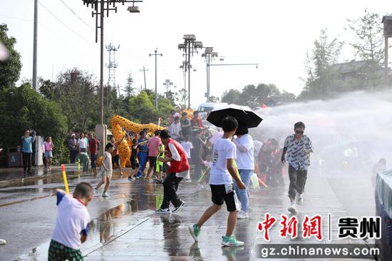 图为游客在贵州省务川县龙潭村水龙节现场玩水狂欢。
