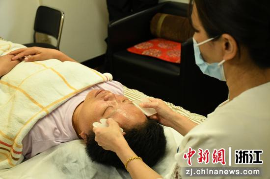 图为浙江省中医院中医护理门诊医护人员为患者进行刮痧治疗缓解失眠症状。  郭天奇 摄