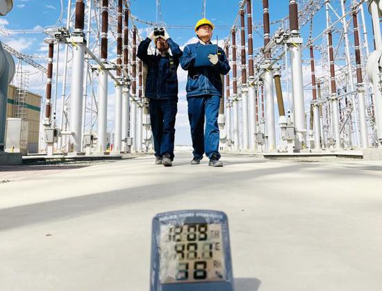 7月17日，室外温度47.1°C，国网新疆超高压分公司员工在750千伏塔城变电站开展迎峰度夏期间设备特殊巡视工作。（吴希宇 摄）