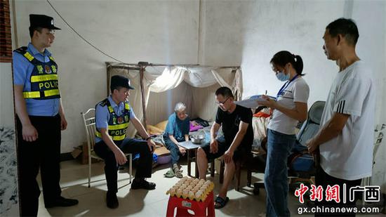 社区民警与网格员上门慰问孤寡老人。农华新 摄