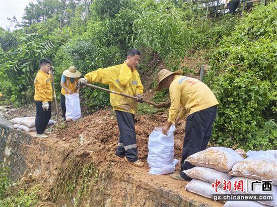 玉林工务段职工在河茂线抢修路堑溜坍处所，用编织袋堆码加固。颜怡  摄