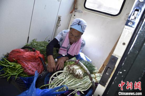 菜农马慧芳在5639次列车上堆码着菜筐里的蔬菜。　沈向全 摄
