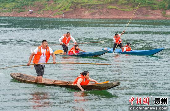 图为村民在务川县参加探秘仡佬 “船”越洪渡 三板船比赛