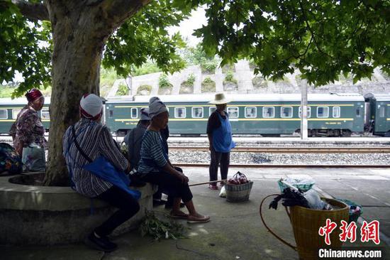 加劳站，村民们围坐在树下乘凉，等候5639次列车进站。　沈向全 摄