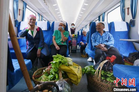 在列车上，杨昌英和同村结伴而行的村民兴高采烈地聊起了今年的收成。　黄春海 摄