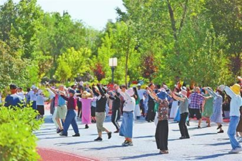 　　7月19日，在鯉魚山公園，市民在綠色掩映中跳起廣場舞。（本報全媒體記者石磊攝）

